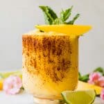 Frozen Mango Margarita recipe on a marble countertop in a glass.