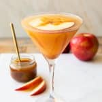 Angled photo of Caramel Apple Martini with a floating apple slice on top.