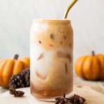 Iced Pumpkin Cream Chai Latte recipe in a glass with a straw.
