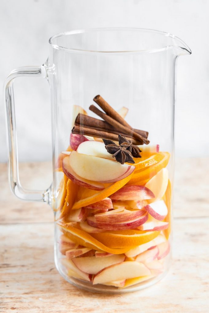 Apple and orange slices in a pitcher.