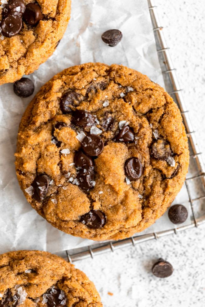 Pumpkin chocolate chip cookie on a cooling rack.