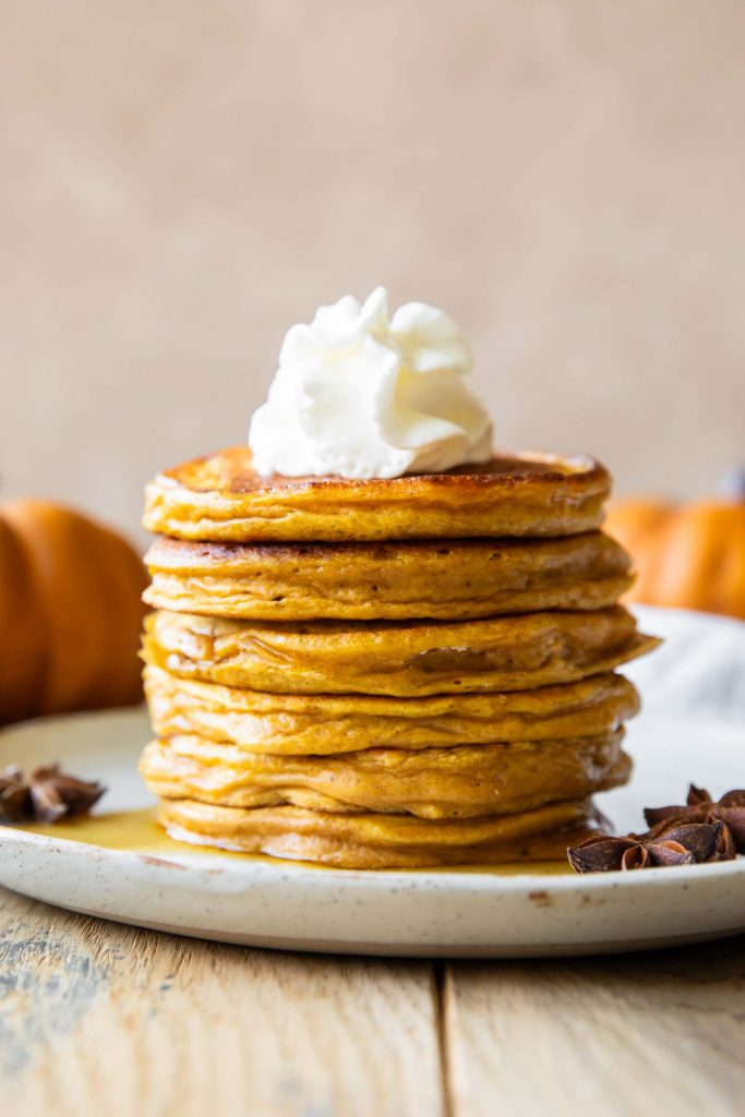 A stack of pumpkin pancakes on a plate.