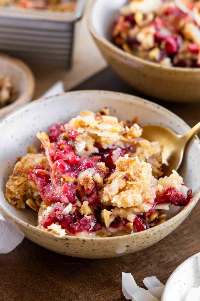 Angled image of cherry pineapple dump cake in a bowl.