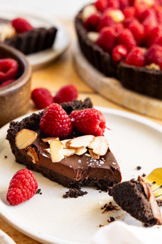 Chocolate tart slice on a plate.