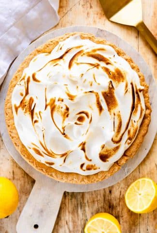 Lemon Meringue Pie on a round cutting board.