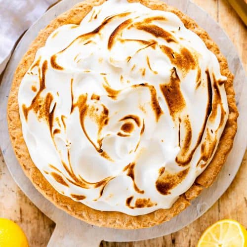 Lemon Meringue Pie on a round cutting board.