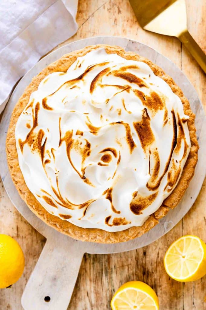 Lemon Meringue Pie on a round cutting board.