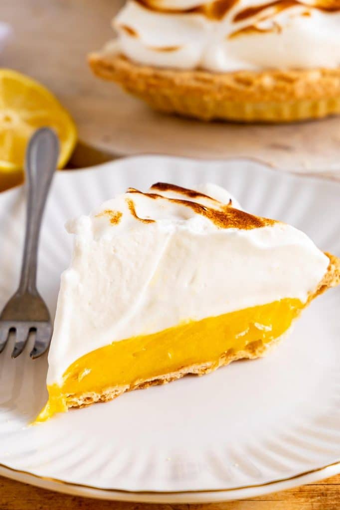 A slice of Lemon meringue Pie on a plate.