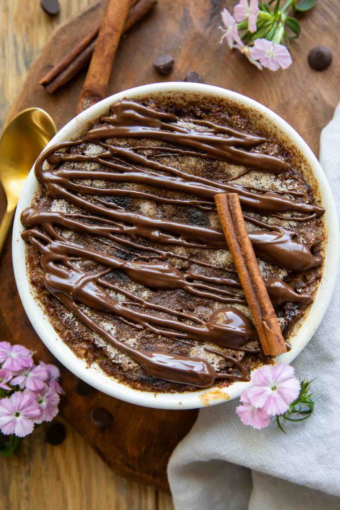 Churro cheesecake baked oats in a white dessert dish.