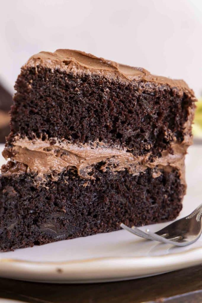 Slice of chocolate zucchini cake on a plate.