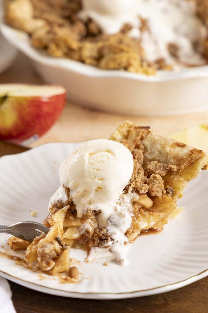 A slice of dutch apple. pie with ice cream.
