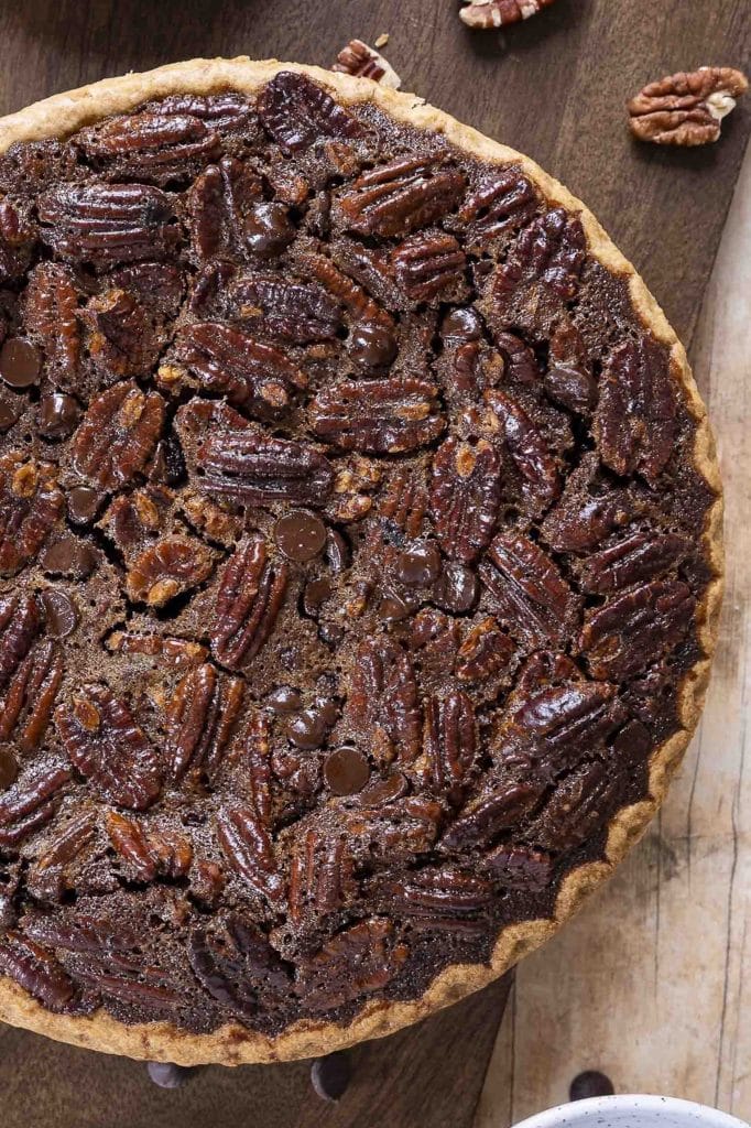 Chocolate pecan pie on a wooden surface.