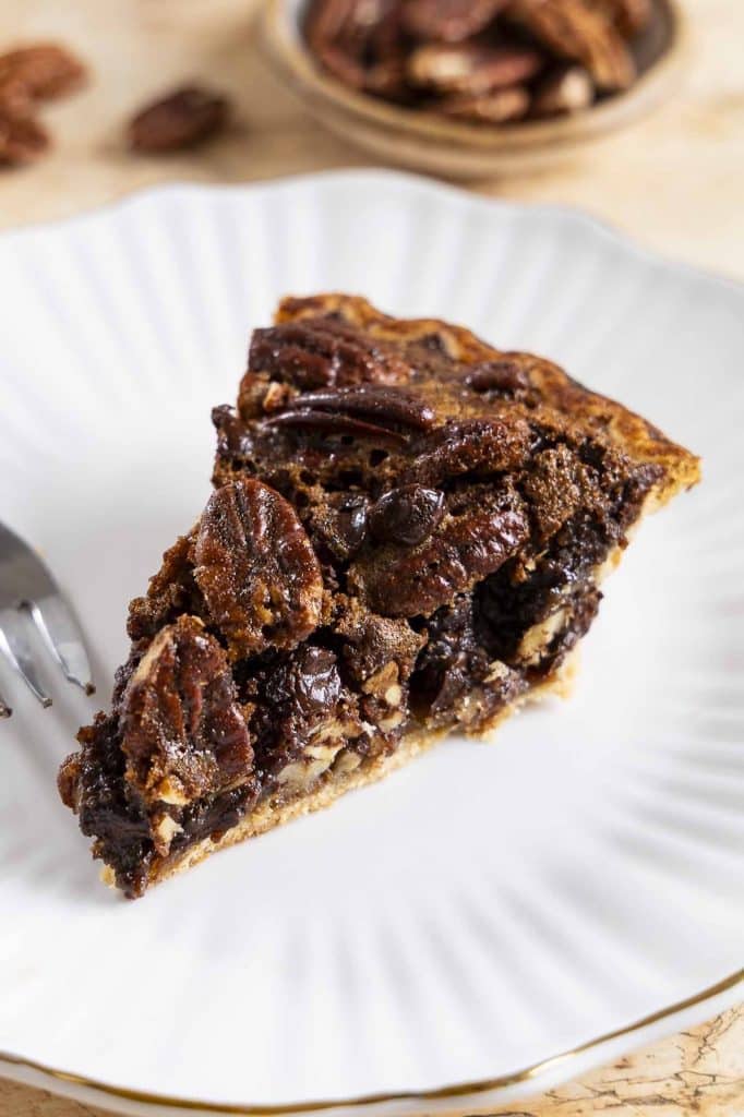 A slice of chocolate pecan pie on a plate.