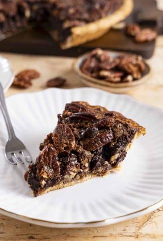A slice of chocolate pecan pie on a plate.
