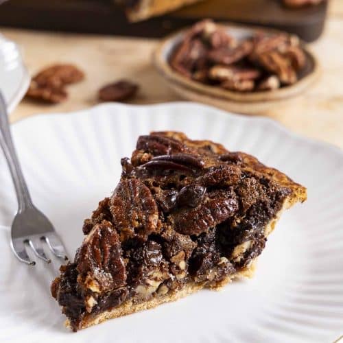 A slice of chocolate pecan pie on a plate.